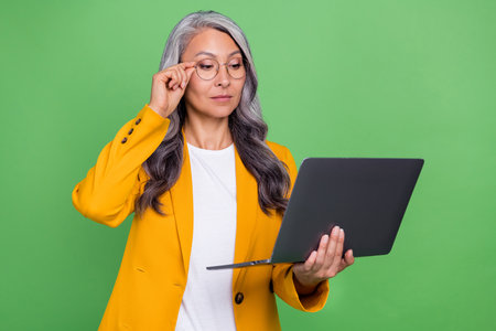Photo of mature woman look laptop report eyeglasses manager banker isolated over green color...