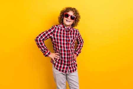 Photo of funky ginger hairstyle small boy wear eyewear red checkered shirt isolated on yellow color backgroundの写真素材