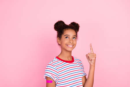 Photo of happy african american brunette small child girl casual wear model point up vaccine...