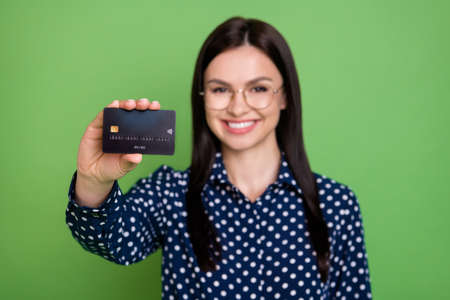 Photo of smart brunette hairdo millennial lady show you card wear spectacles dotted shirt isolated...