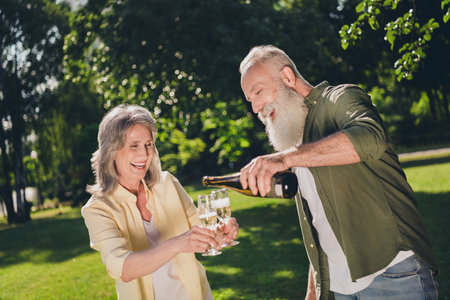 Photo of impressed old couple drink alcohol wear shirt walk in park outside outdoorsの写真素材