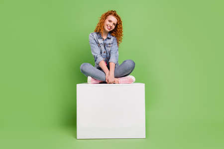 Full size photo of young attractive girl happy positive smile sit lotus pose isolated over green color backgroundの写真素材