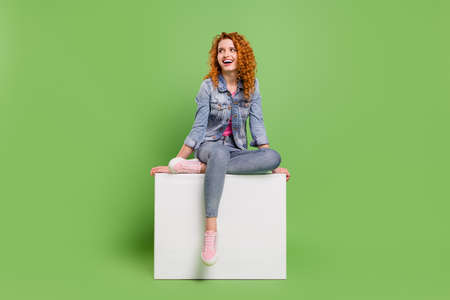 Full body photo of young excited girl happy positive smile curious look empty space isolated over green color backgroundの写真素材