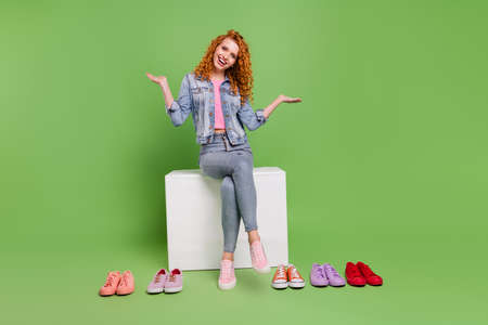 Full length photo of young girl happy positive smile think what to buy sneakers shopaholic isolated over green color backgroundの写真素材