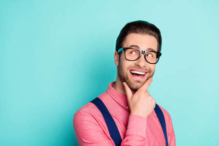 Photo of young cheerful man happy positive smile curious dream look empty space isolated over teal color backgroundの写真素材