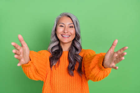 Photo of cute white hairdo aged lady hug camera wear pullover isolated on green background