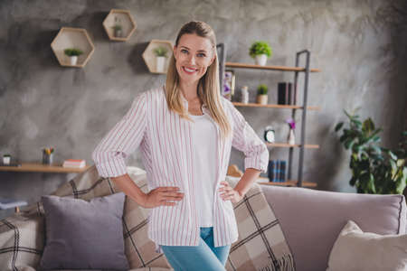 Photo of lovely young blond lady stand wear white shirt jeans on quarantine at home aloneの写真素材