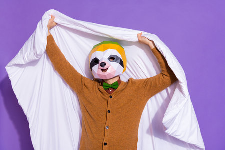 Photo of young man hold duvet bedroom sleepy incognito red panda isolated over purple color backgroundの写真素材