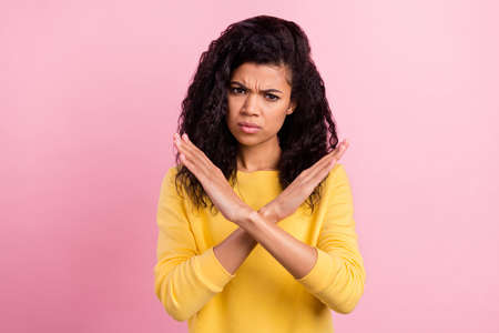 Photo of young black girl crossed hands show no stop refuse denial sign isolated over pink color backgroundの写真素材