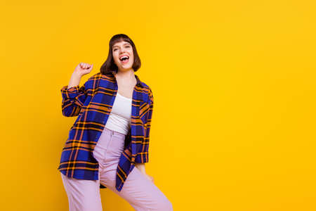 Portrait of attractive cheerful girl rest chill out good mood having fun copy space isolated over bright yellow color backgroundの写真素材