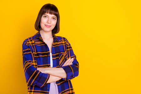 Portrait of attractive cheery girl folded arms copy space isolated over bright yellow color backgroundの写真素材