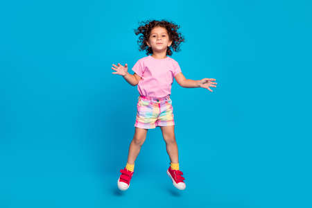 Full length body size view of attractive cheerful carefree funky girl jumping fooling isolated over vivid blue color backgroundの写真素材