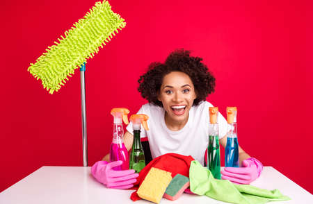 Photo portrait woman laughing keeping cleaning equipment bottles isolated vivid red color backgroundの写真素材