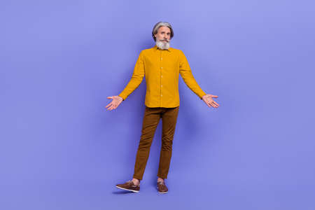 Full length photo of mature man misunderstanding wear modern outfit isolated over purple color backgroundの写真素材