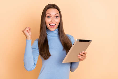 Photo of hooray brunette millennial lady hold tablet yell wear blue sweater isolated on beige color backgroundの写真素材