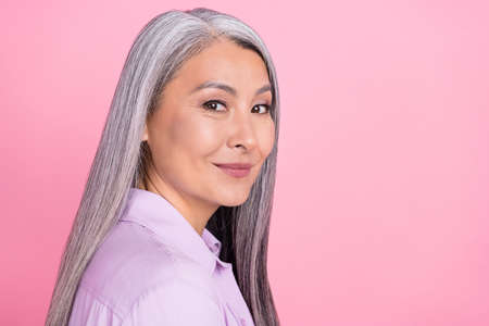 Profile side view portrait of attractive well-groomed cheery gray-haired woman copy space isolated over pink pastel color backgroundの写真素材