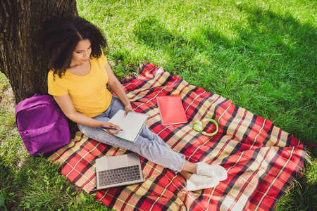 Top above high angle view portrait of attractive focused girl sitting on cover writing home work...