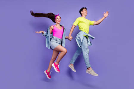 Profile photo of cheerful glad friends couple jump run wear denim pin-up outfit isolated violet color backgroundの写真素材