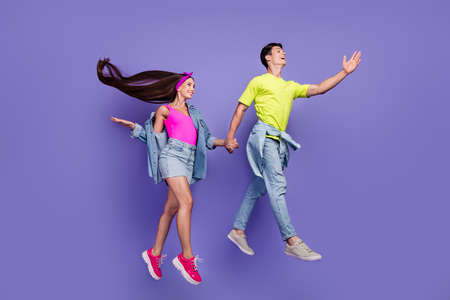 Profile photo of dreamy youngster couple jump hold hands wear pin-up outfit isolated violet color backgroundの写真素材