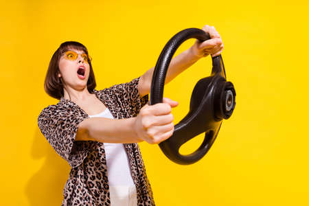 Photo of unexpected young lady drive staring wear eyewear shirt isolated on yellow color background