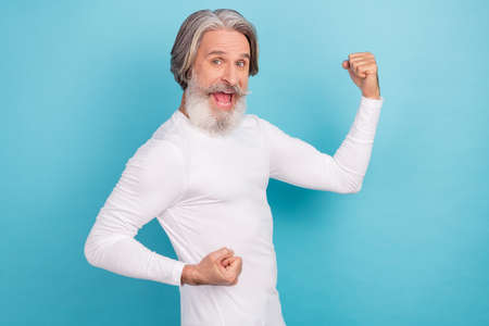 Portrait of attractive cheerful lucky grey-haired man celebrating success having fun isolated over...