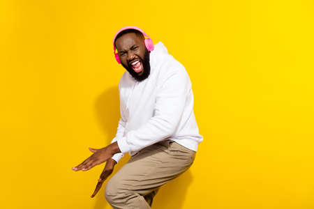 Profile photo of funky millennial brunet man dance listen music wear headphones hoodie pants...