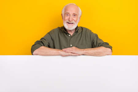 Photo of optimistic elder beard man near promo wear khaki outfit isolated on yellow color background