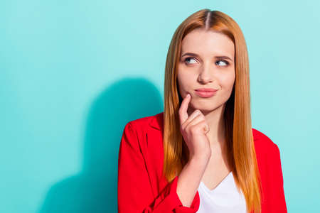 Photo of adorable pretty orange hair woman dressed red jacket finger chin empty space isolated aquamarine color backgroundの写真素材
