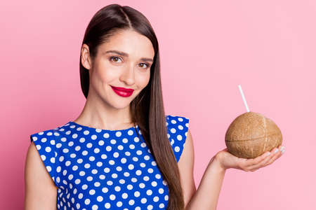 Photo of young woman happy positive smile hold coconut drink cocktail vacation isolated over pastel color backgroundの写真素材