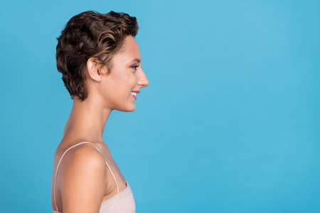 Photo of sweet pretty young woman dressed beige top looking empty space smiling isolated blue color...