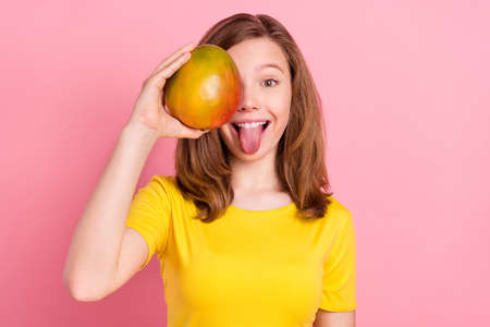 Photo of young girl happy positive smile cover eye mangor tongue-out grimace isolated over pink color backgroundの写真素材