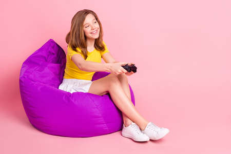Full length profile side photo of young girl happy smile play video game joystick chair bean...