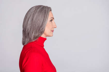 Profile side photo of attractive senior woman serious look empty space isolated over grey color backgroundの写真素材