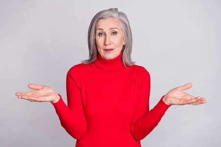 Photo of senior woman happy positive smile shrug shoulders clueless confused no answer isolated over...
