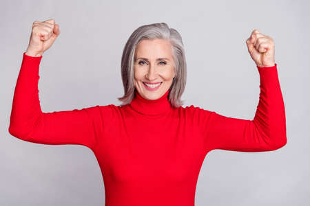 Photo of senior woman happy positive smile rejoice victory success fists hands isolated over grey color backgroundの写真素材