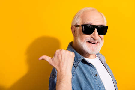 Photo of positive person toothy smile indicate thumb empty space proposition isolated on yellow...