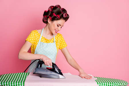 Photo of focused positive girl iron t-shirt board isolated over pastel color backgroundの写真素材