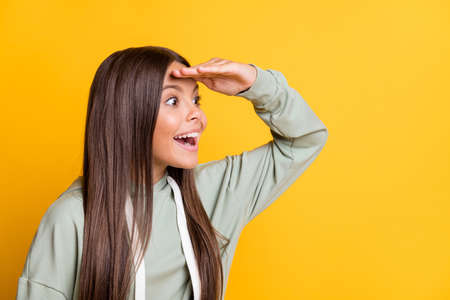 Photo of charming adorable child girl dressed casual green outfit looking far away empty space arm...