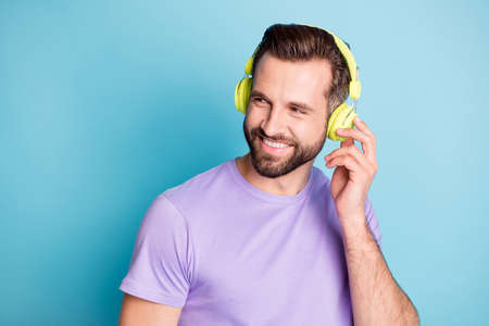 Photo portrait of funky happy student touching green headphones enjoying music smiling isolated on...