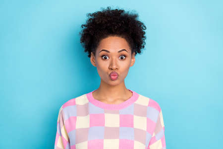 Portrait of attractive funny wavy-haired girl sending air kiss isolated over pastel blue vivid color backgroundの写真素材