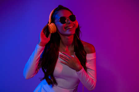 Photo of nice young dancer brunette lady listen music look empty space wearing white dress eyewear...