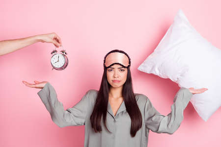 Portrait of beautiful trendy depressed girl wake up call awake early day isolated over pink pastel color backgroundの写真素材