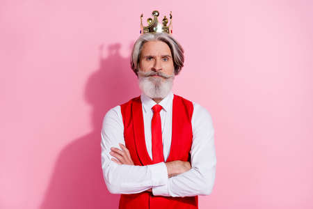 Portrait of attractive serious content grey-haired man wearing retro vest crown folded arms isolated over pink pastel color backgroundの写真素材