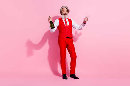 Full length body size view of attractive cheery amazed trendy grey-haired man drinking wine invite isolated over pink pastel color backgroundの写真素材