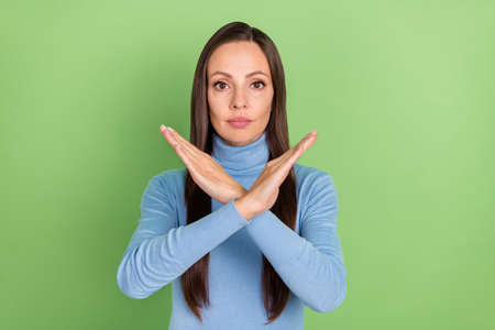 Portrait of attractive strict long-haired girl showing crossed hands stop sign isolated over bright...