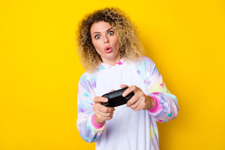 Portrait of attractive amazed addicted wavy-haired girl in pajama playing video game pout lips...