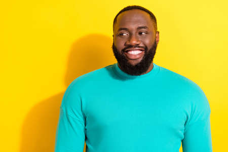 Portrait of candid friendly person toothy smile look interested empty space isolated on yellow color backgroundの写真素材