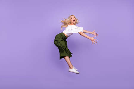 Full length body size girl jumping up laughing flying on wind in bad weather isolated pastel purple...