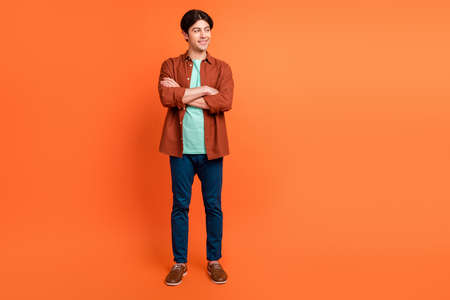 Full size photo of positive good mood handsome male with folded hands look copyspace isolated on...