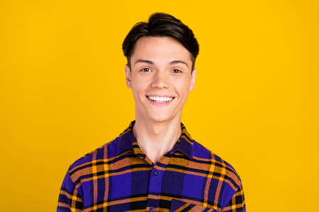 Photo of nice brunet young guy wear plaid shirt isolated on yellow color backgroundの写真素材